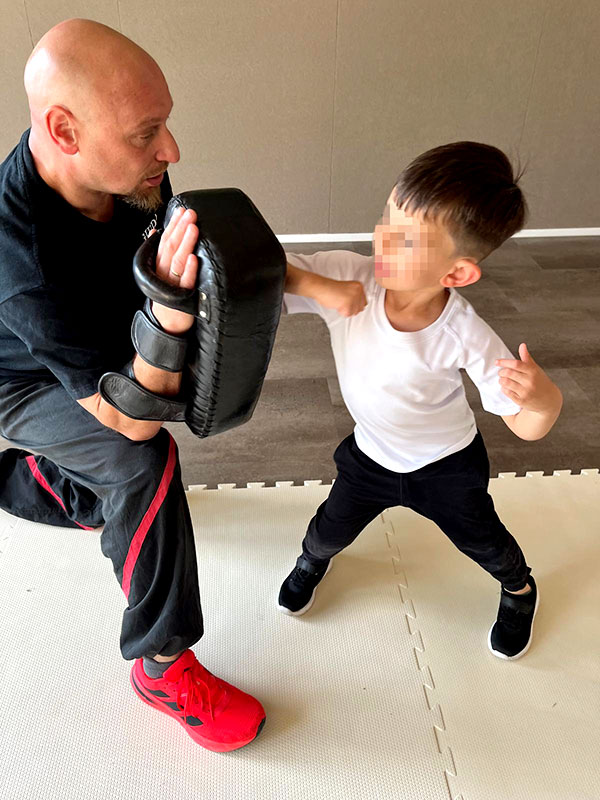 Kindertraining mit Trainer und Schlagpolster